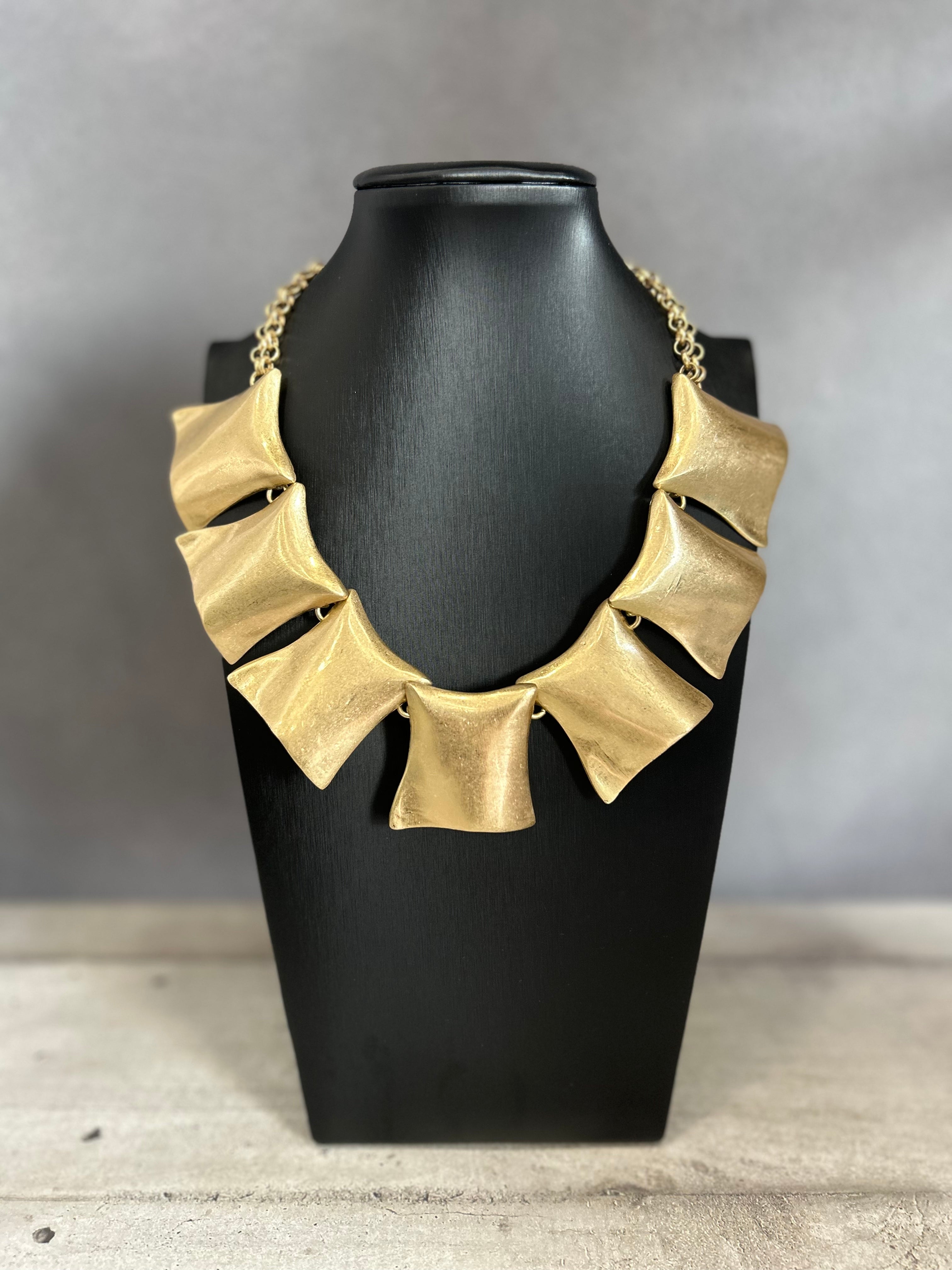 Collana con elementi scultorei in metallo dorato