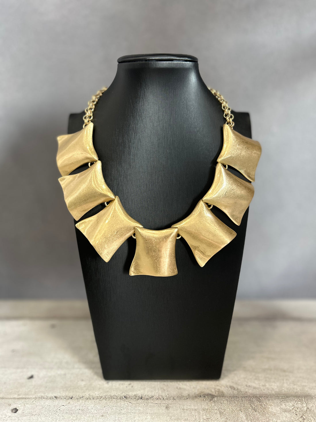 Collana con elementi scultorei in metallo dorato